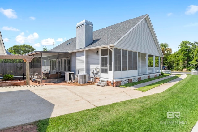 4001 Landfall Dr, Pensacola, FL 32507 - back of property with a shingled roof, a sunroom, a patio, and a yard