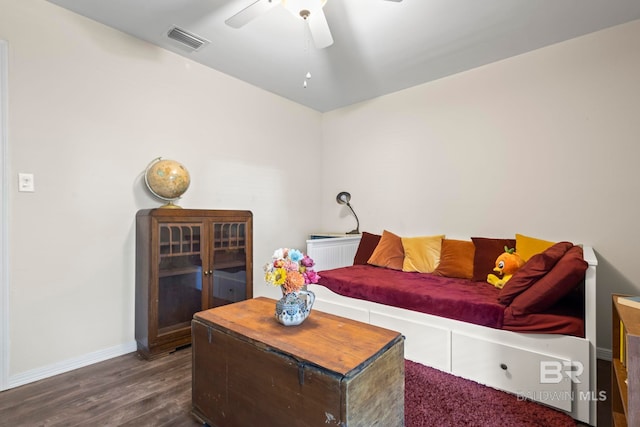 living room with ceiling fan and dark wood-type flooring