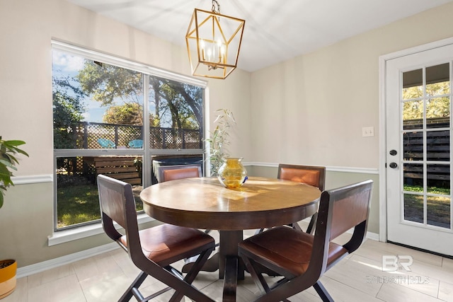 dining room featuring light tile patterned floors, a healthy amount of sunlight, and an inviting chandelier