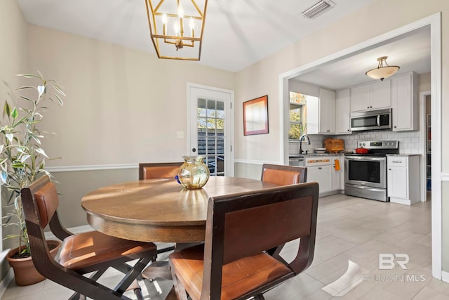 dining space with light tile patterned flooring and a chandelier