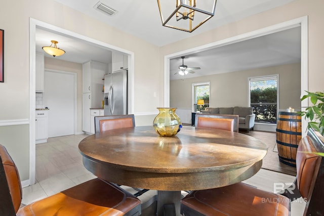 dining area featuring ceiling fan with notable chandelier