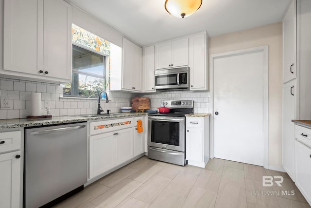 kitchen featuring white cabinets, decorative backsplash, and appliances with stainless steel finishes