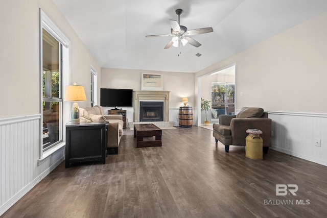 living room with a wealth of natural light, dark hardwood / wood-style flooring, ceiling fan, and lofted ceiling