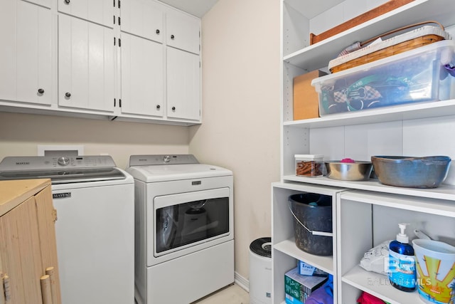 washroom with cabinets and washer and dryer