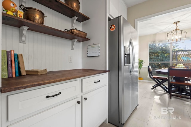 kitchen featuring wooden counters, stainless steel fridge with ice dispenser, a chandelier, and white cabinetry