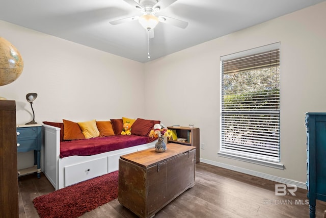 living room featuring ceiling fan and dark wood-type flooring