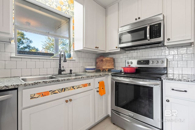 kitchen with sink, white cabinetry, stainless steel appliances, and tasteful backsplash