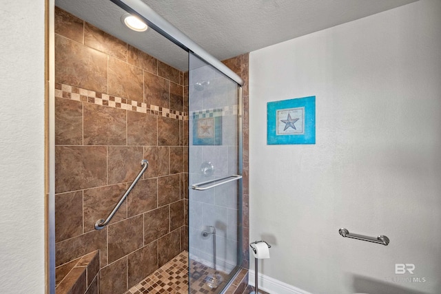 bathroom with an enclosed shower and a textured ceiling