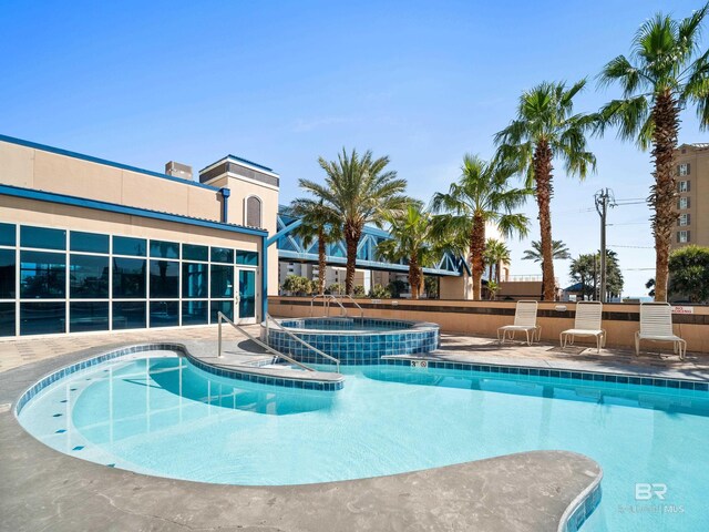 view of swimming pool featuring a community hot tub and a patio