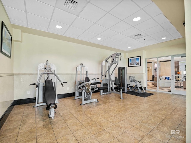 workout area with light tile patterned floors and a paneled ceiling