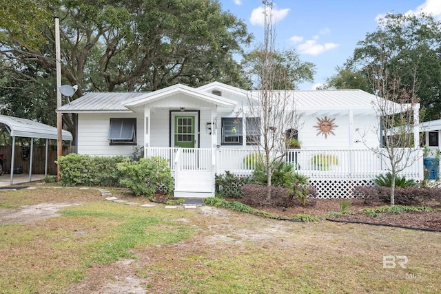 view of front of home featuring covered porch, a front yard, and a carport