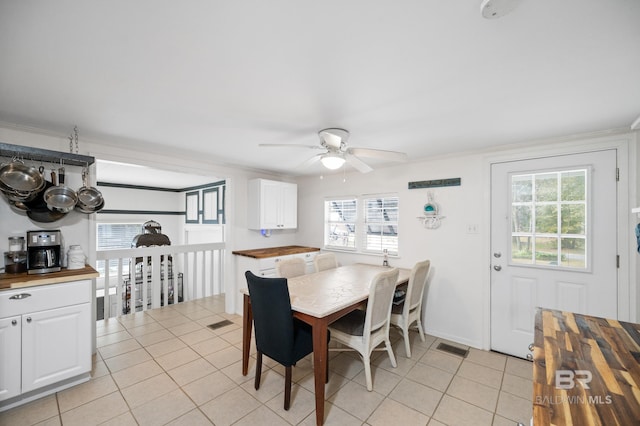 dining space featuring ceiling fan, light tile patterned floors, and crown molding