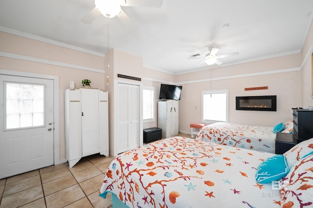 tiled bedroom featuring ceiling fan and crown molding