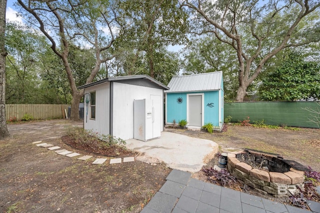 view of outbuilding featuring an outdoor fire pit