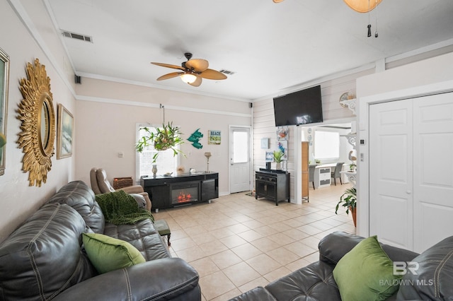 living room featuring ceiling fan, light tile patterned flooring, and ornamental molding