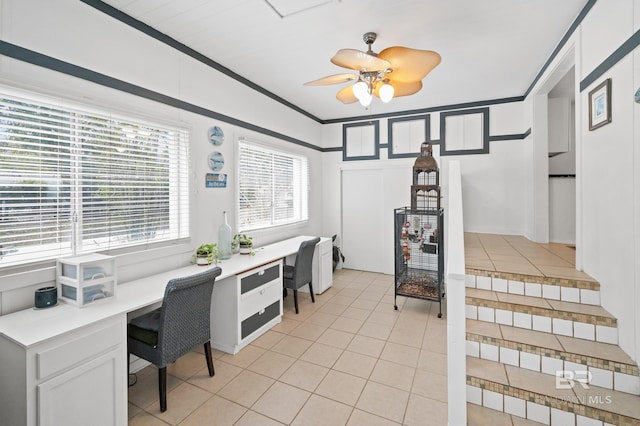 home office with light tile patterned floors, ornamental molding, built in desk, and ceiling fan