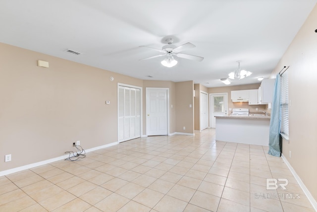 unfurnished living room featuring light tile patterned floors and ceiling fan with notable chandelier