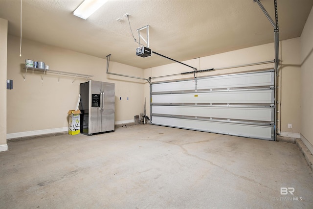 garage with stainless steel refrigerator with ice dispenser and a garage door opener