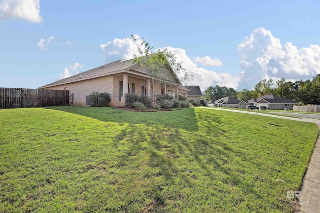 view of side of home with a yard