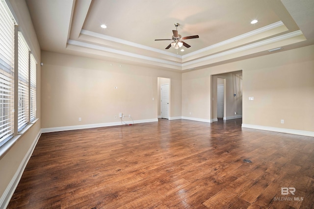 spare room featuring ornamental molding, a tray ceiling, and dark hardwood / wood-style floors