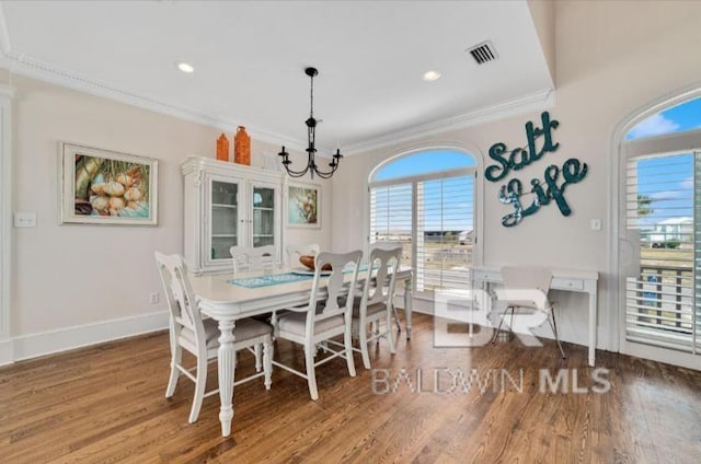2223 W Beach Blvd, Gulf Shores, AL 36542 - dining room featuring ornamental molding, baseboards, visible vents, a notable chandelier, and wood finished floors
