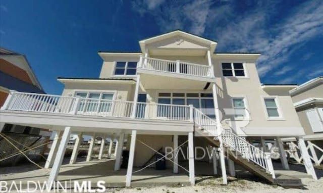 2223 W Beach Blvd, Gulf Shores, AL 36542 - rear view of house with a balcony and stairway