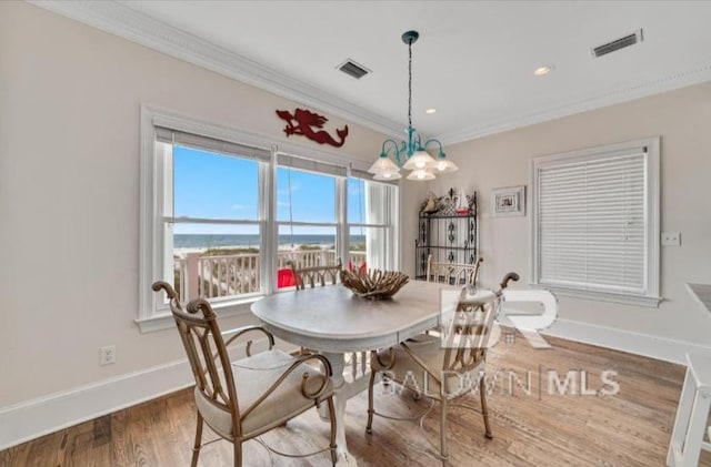 2223 W Beach Blvd, Gulf Shores, AL 36542 - dining space with wood finished floors, crown molding, baseboards, and visible vents