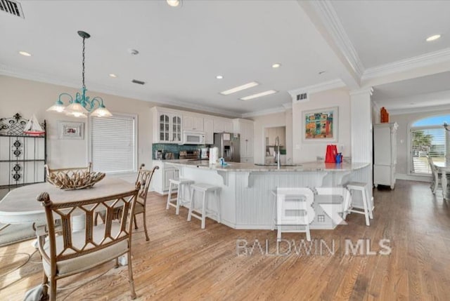 2223 W Beach Blvd, Gulf Shores, AL 36542 - kitchen with a kitchen breakfast bar, stainless steel fridge with ice dispenser, visible vents, a peninsula, and white microwave