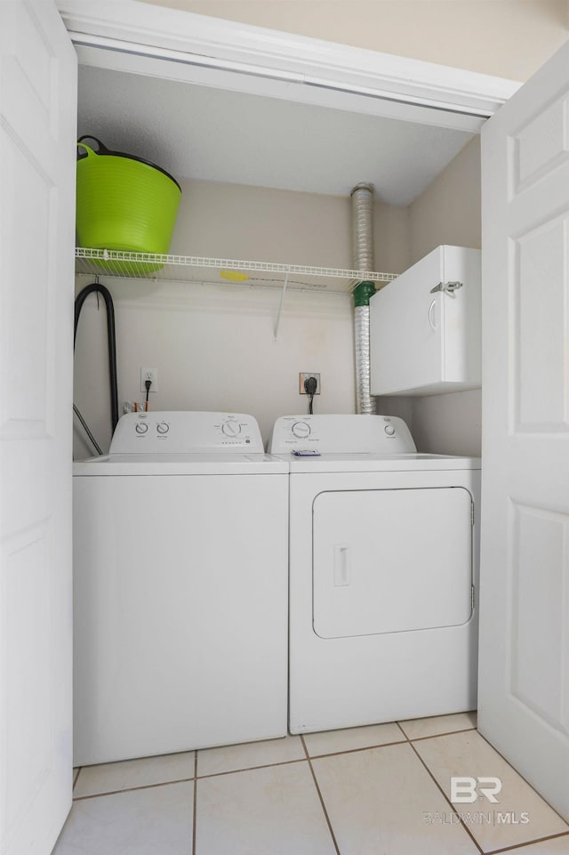 laundry area with light tile patterned floors and independent washer and dryer