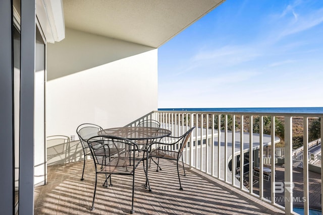 balcony featuring a water view and a view of the beach