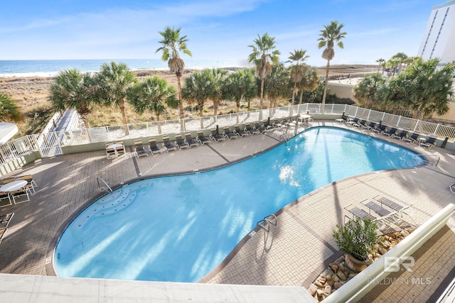 view of swimming pool with a patio area and a water view