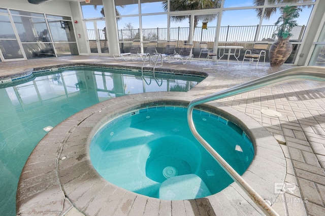 view of swimming pool with an indoor in ground hot tub, a patio, and a lanai