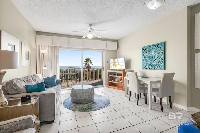 living room with light tile patterned floors, a textured ceiling, and ceiling fan