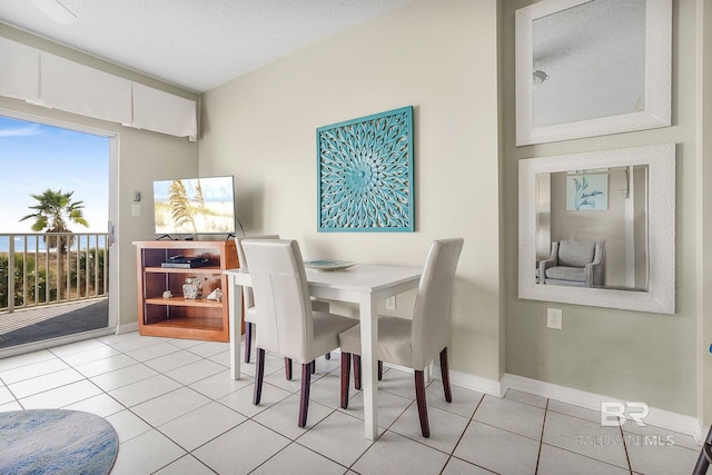 dining area with light tile patterned floors and a textured ceiling