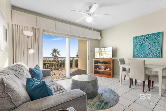 tiled living room with ceiling fan and a textured ceiling