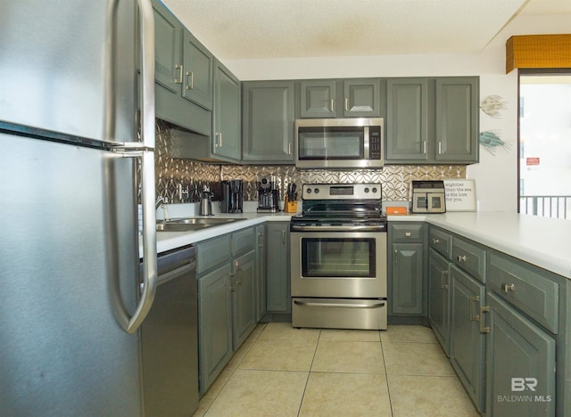 kitchen featuring tasteful backsplash, sink, light tile patterned floors, and stainless steel appliances