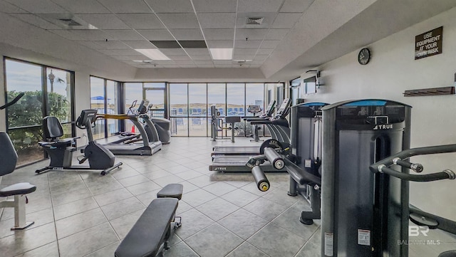 workout area with a drop ceiling and light tile patterned floors