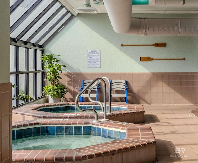 view of swimming pool featuring an indoor hot tub and a skylight