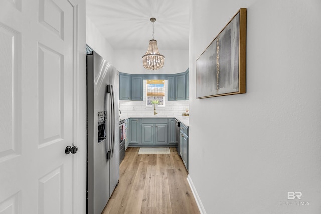 4 Yacht Club Dr Unit 15, Daphne, AL 36526 - kitchen featuring stainless steel fridge, decorative backsplash, light wood finished floors, a sink, and a chandelier