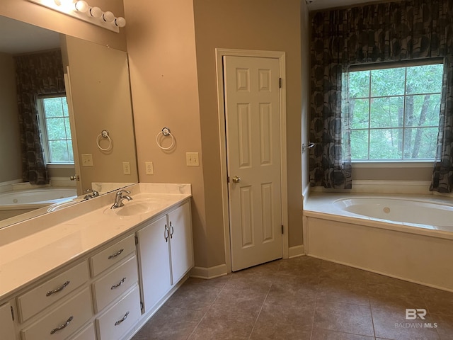 full bathroom featuring a garden tub, vanity, and tile patterned flooring