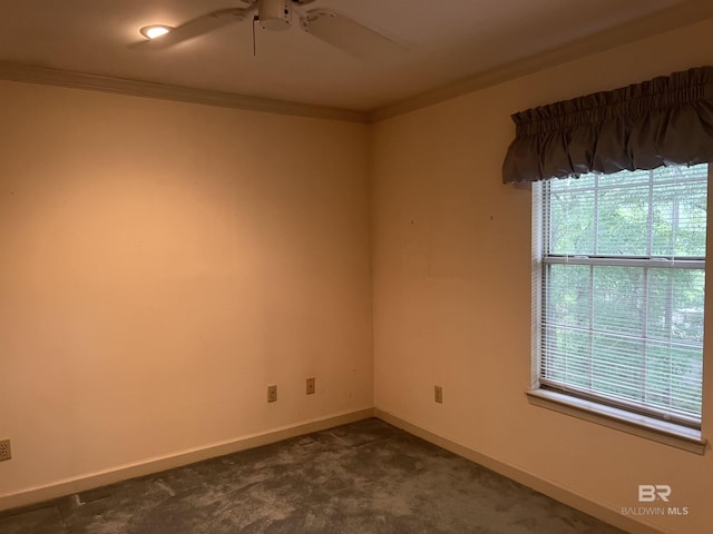 empty room with a ceiling fan, ornamental molding, baseboards, and dark colored carpet