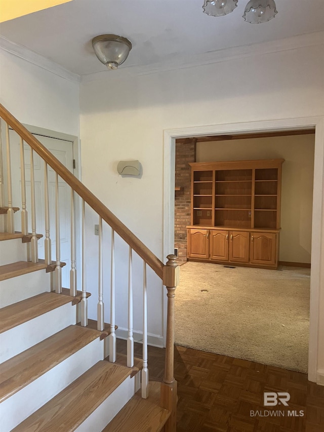 staircase featuring carpet, crown molding, and baseboards