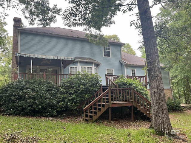 back of house with a chimney, a deck, and stairway