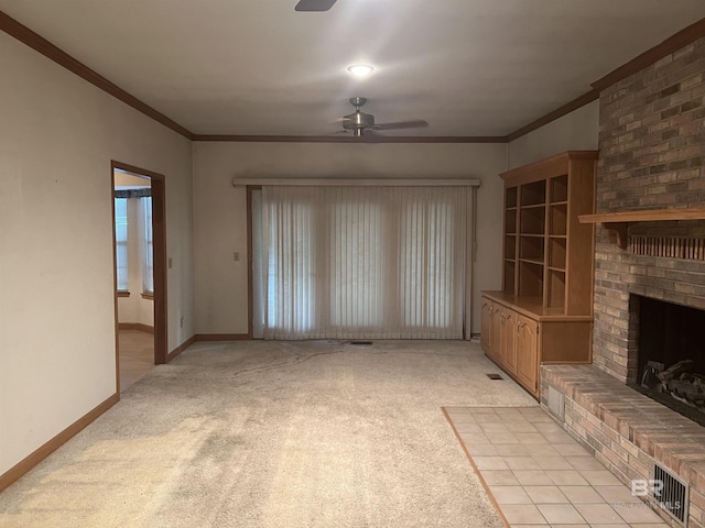 unfurnished living room featuring a ceiling fan, light carpet, a brick fireplace, ornamental molding, and baseboards