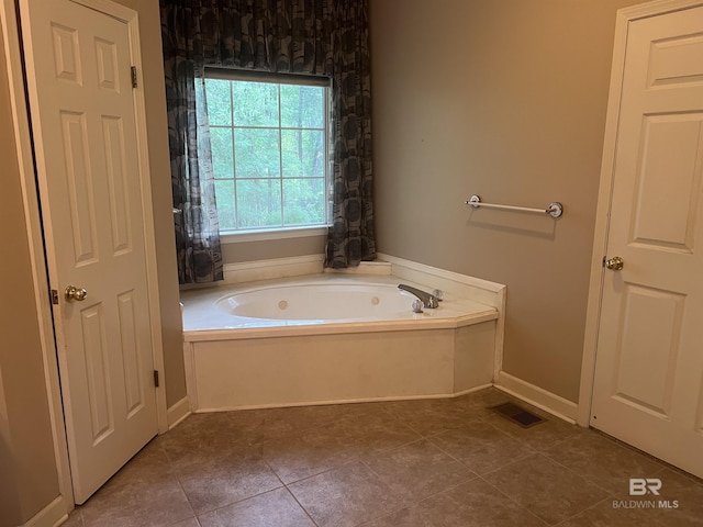 bathroom featuring a garden tub and tile patterned flooring