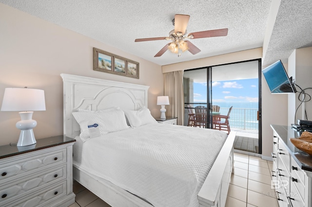 bedroom featuring access to outside, ceiling fan, a textured ceiling, and light tile patterned floors