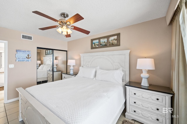 bedroom with visible vents, ceiling fan, a textured ceiling, and light tile patterned floors