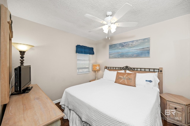 bedroom with ceiling fan and a textured ceiling