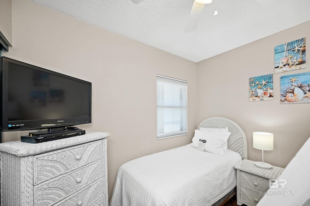 bedroom with a ceiling fan and a textured ceiling