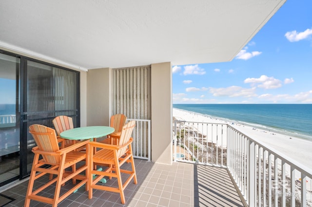 balcony featuring a beach view and a water view